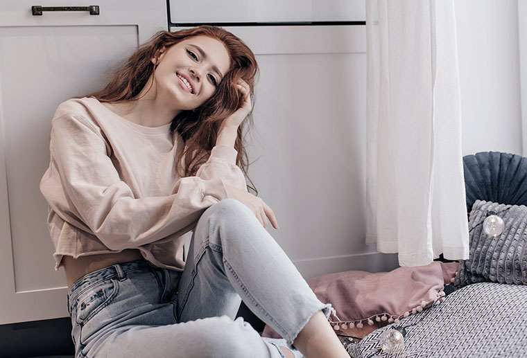 Woman smiling while enjoying warm home maintained by Ricks Affordable Heating and Cooling in Perrysburg, Ohio