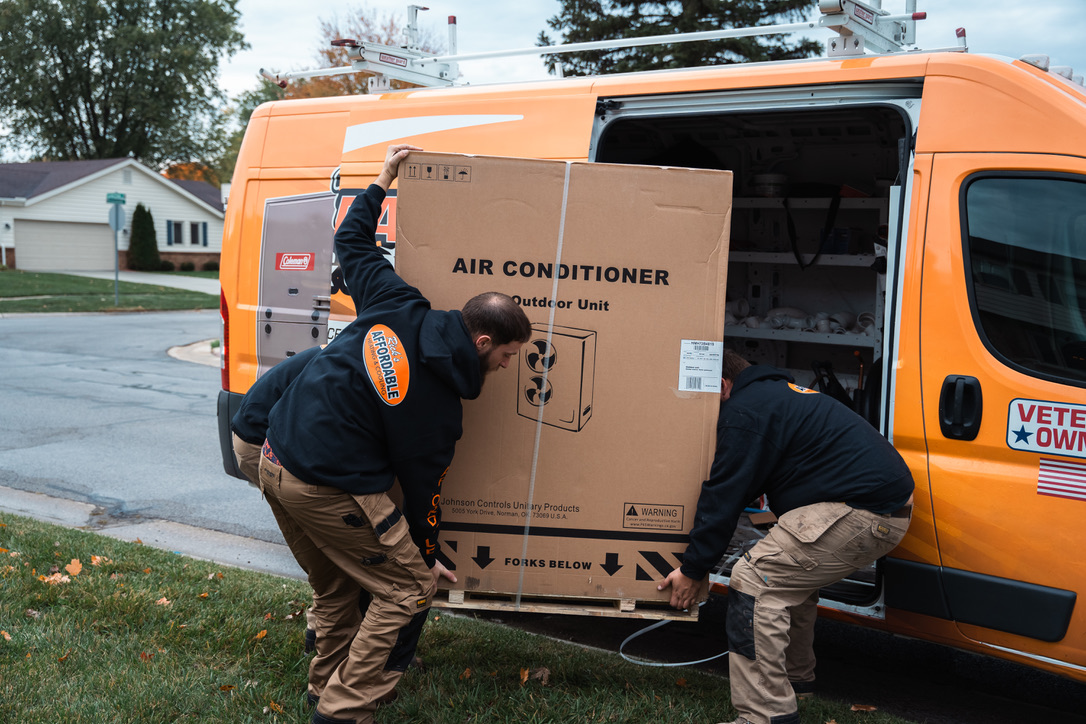 Rick's Affordable team unloading AC equipment from the service van for installation