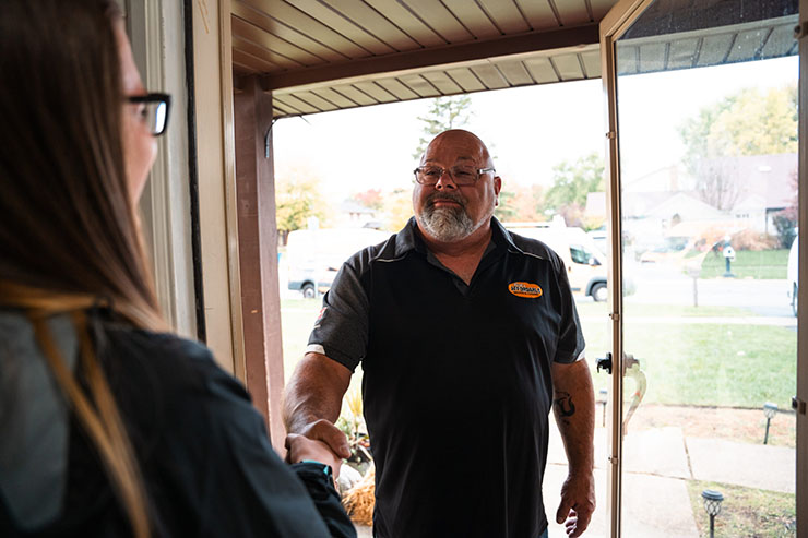 HVAC technician from Rick's Affordable Heating and Cooling in Sylvania, OH greeting customer at door
