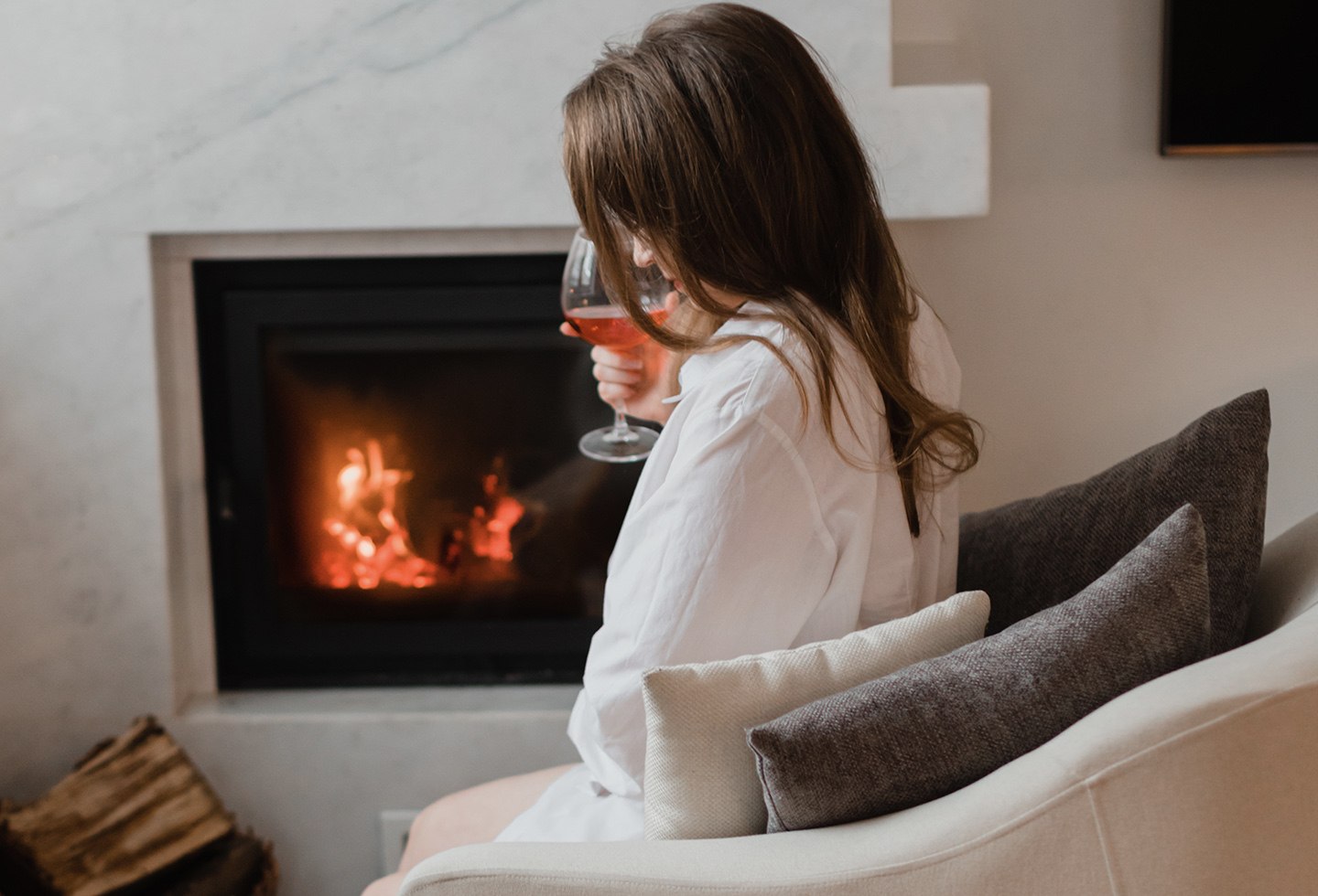 Woman sits by fireplace following furnace repair in Perrysburg, Ohio by Ricks Affordable Heating & Cooling