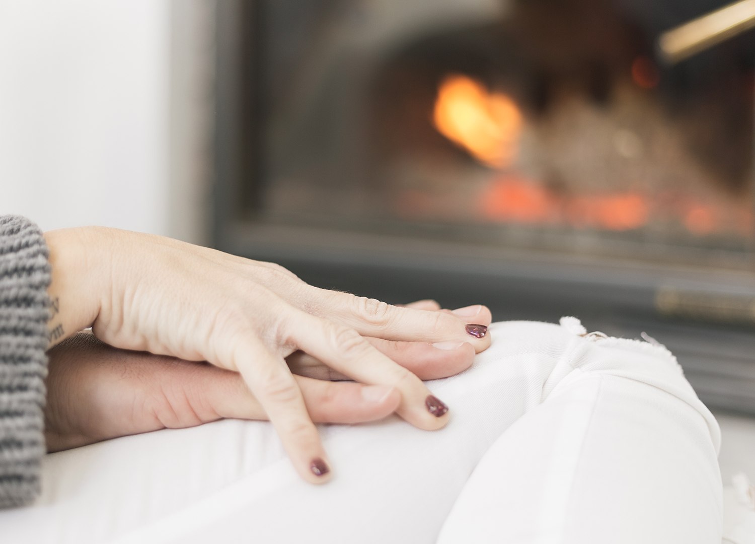 Couple's hands near fireplace following furnace repair in Perrysburg, Ohio by Ricks Affordable Heating & Cooling