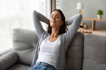 A woman breathing deeply and smiling in her home