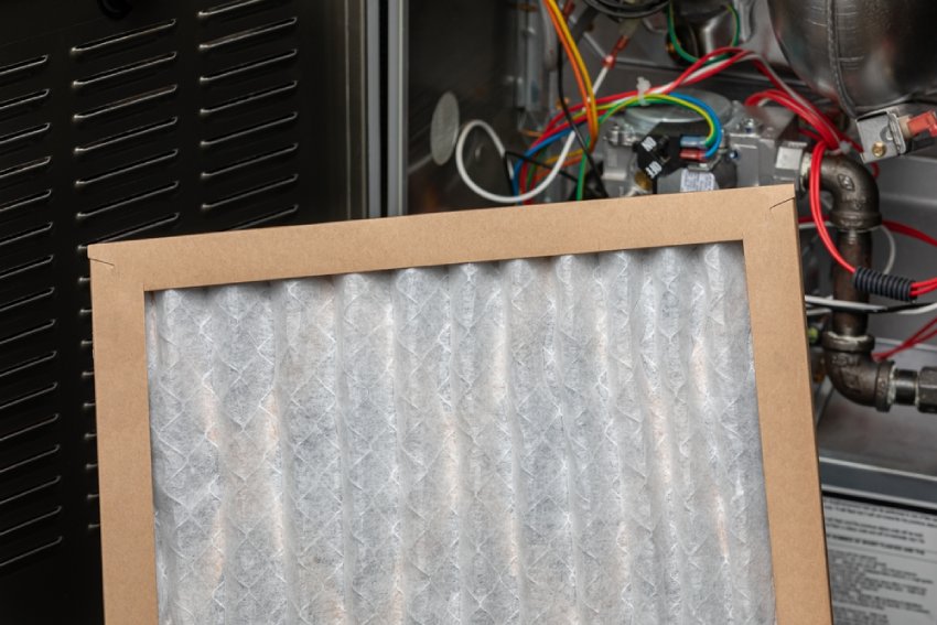 A technician installing a furnace filter.