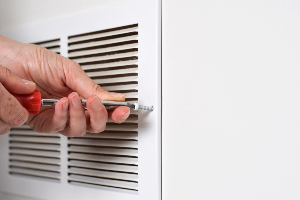 What Noises from Your Furnace Mean & When to Call a Pro 1 Checking a furnace vent and duct.